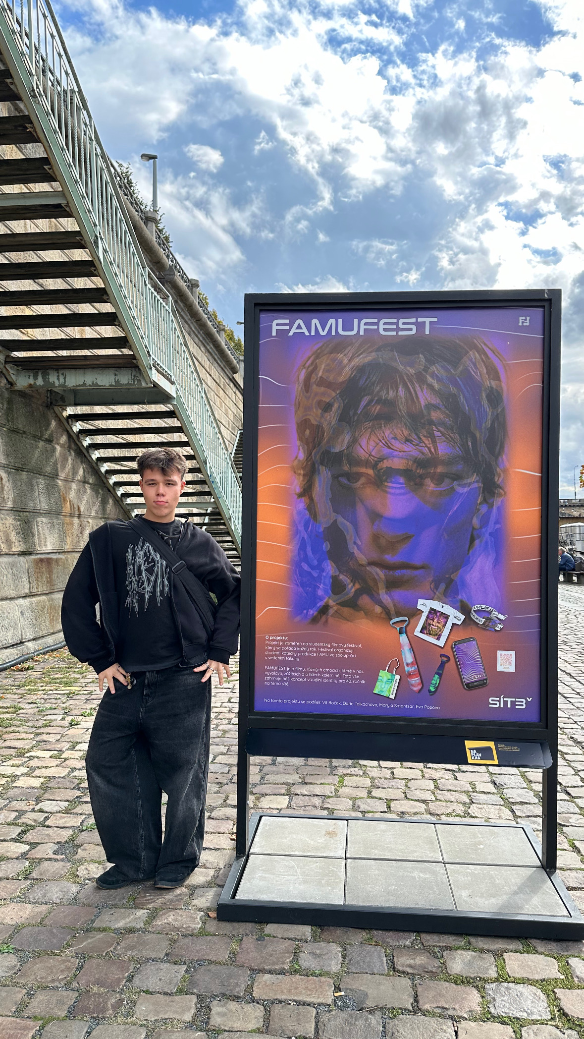 A full body picture of me proudly looking straight to the camere, standing next to my work on Náplavka